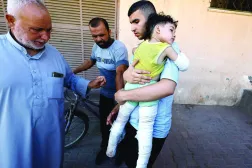 A Palestinian carries a child wounded in an Israeli strike that killed the child’s parents at Al-Aqsa Martyrs Hospital in Deir al-Balah, central Gaza Strip, July 15, 2026 (Reuters) 