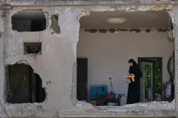Geçtiğimiz perşembe günü İsrail bombardımanına hedef olan Arabsalim kasabasındaki evini inceleyen bir kadın (AP)