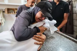 فلسطينية تودع شقيقتها إسراء الحاسي (7 سنوات) بعد أن قُتلت بنيران الجيش الإسرائيلي وسط غزة يوم الثلاثاء (أ.ف.ب)