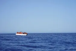 مهاجرون على متن قارب ينتظرون المساعدة من قارب إنقاذ في المياه الدولية جنوب لامبيدوزا بالبحر المتوسط 24 يوليو 2025 (رويترز)