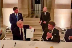 Trump, 18 Haziran akşamı Versailles Sarayı'nda imzalanmasının ardından İran ile varılan "çerçeve anlaşma" belgesini gösteriyor. (AFP)
