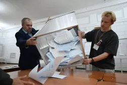 عاملان في لجنة انتخابية يفرغان صندوق اقتراع لعد الأصوات بمدينة كراسنويارسك في سيبريا الأحد (د.ب.أ)
