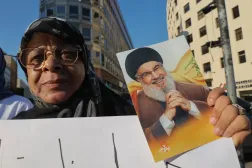 Hizbullah destekçisi bir kadın, ABD arabuluculuğunda yürütülen Lübnan-İsrail müzakerelerine karşı Beyrut merkezindeki protestolar sırasında, örgütün eski Genel Sekreteri Hasan Nasrallah’ın fotoğrafını taşıyor (Arşiv- EPA)