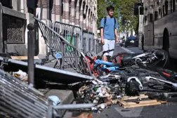 Paris’te lise öğrencilerinin düzenlediği protesto sırasında polis ile göstericiler arasında çıkan çatışmaların ardından bölgede meydana gelen yıkımın izleri önünden geçen bir kişi (EPA)
