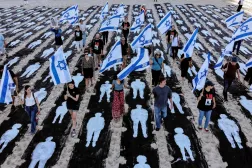 Tel Aviv’de bir sahilde 7 Ekim saldırısının üçüncü yıl dönümü anısına kurulan anıtın içinden İsrail bayrakları taşıyarak geçen insanların havadan görünümü. (AFP) 