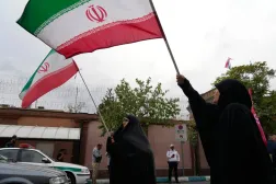  Iranian women hold their country's flags during a protest to condemn France's "violent crackdown on students demonstrations and human rights violations" in front of the French Embassy in Tehran, Iran, Saturday, Oct. 10, 2026. (AP) 