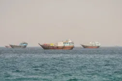 سفن تعبر مضيق هرمز كما تبدو من شبه جزيرة مسندم العُمانية يوم الاثنين (رويترز)