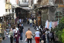 Syrians walk past shops down an alley at the Old City in Damascus on October 21, 2026. (Photo by LOUAI BESHARA / AFP)