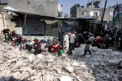 People seek cover from a reported drone strike while they were queuing to receive meals from a charity kitchen in the Jabalia camp for Palestinian refugees in the northern Gaza Strip on October 24, 2026. (AFP)