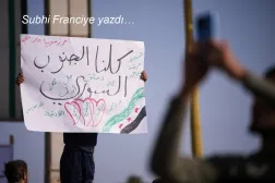 Suriye'nin Dera şehrinde, Kuneytra ve batı Dera bölgelerine yönelik İsrail askeri müdahalelerine karşı düzenlenen protestoda, bir gösterici Arapça olarak “Hepimiz Güney Suriye'yiz” yazılı pankart taşıyor, 23 Ekim 2026
