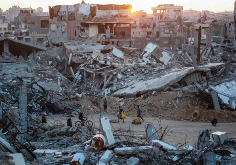 فلسطينيون يسيرون في حي مدمر بسبب الغارات الإسرائيلية على مدينة خان يونس جنوب قطاع غزة (أ.ف.ب)