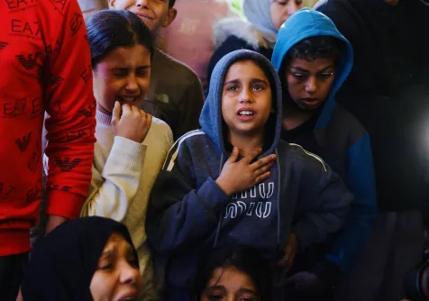 أطفال فلسطينيون يبكون خلال حضور جنازة أشخاص قُتلوا في خان يونس (أ.ف.ب)