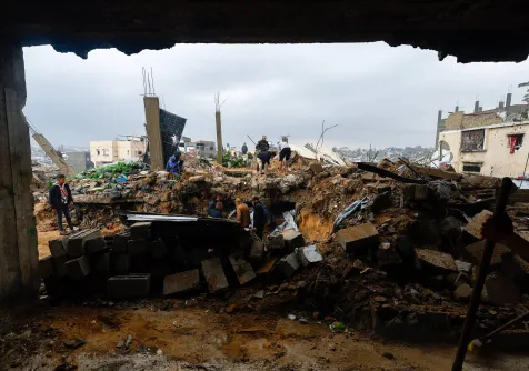 فلسطينيون يبحثون عن ضحايا جراء انهيار منزل متضرر من القصف الإسرائيلي على قطاع غزة (رويترز) 