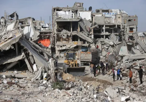 إزالة حطام المباني والمنازل المدمرة في خان يونس جنوب قطاع غزة (أ.ف.ب)