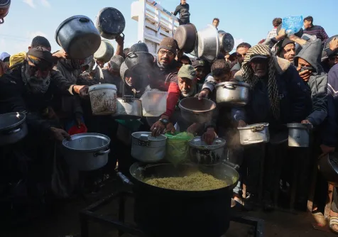 تجمُّع فلسطينيين نازحين لتلقي حصص غذائية في مطبخ خيري بخان يونس جنوب قطاع غزة (أ.ف.ب)