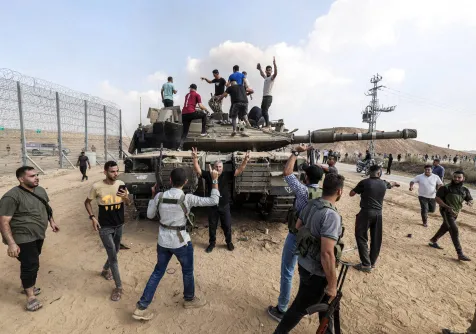 فلسطينيون فوق دبابة إسرائيلية سيطر عليها مقاتلو «كتائب القسام» قرب خان يونس في 7 أكتوبر 2023 (د.ب.أ)