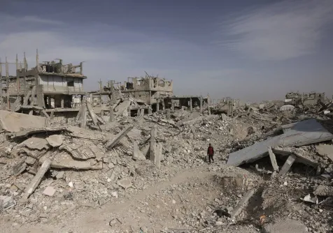 فلسطيني يمشي وسط أنقاض المباني المدمرة جنوب قطاع غزة (أ.ف.ب)