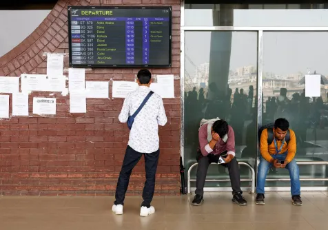 ركاب عالقون ينتظرون في مطار حضرة شاه جلال الدولي بعد إلغاء رحلات جوية إلى دبي والبحرين عقب غارات إيرانية (رويترز)