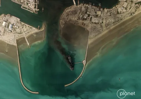 صورة بالأقمار الصناعية تُظهر تصاعد الدخان من سفينة في مضيق هرمز (أ.ف.ب)