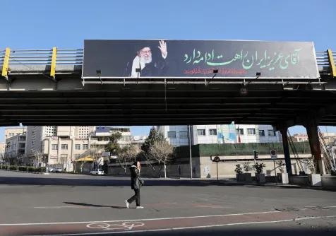 إيرانية تمر أمام لوحة عليها صورة المرشد علي خامنئي في أحد شوارع طهران (رويترز)
