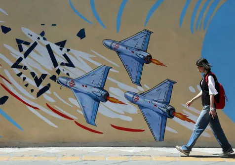 إيرانية تمر أمام لوحة جدارية مناهضة للولايات المتحدة وإسرائيل في طهران الأربعاء (إ.ب.أ)