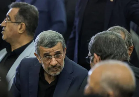 أحمدي نجاد يتحدث إلى أشخاص خلال مراسم تأبين المرشد السابق بحضور كبار المسؤولين الإيرانيين في طهران الثلاثاء (دولت بهار)