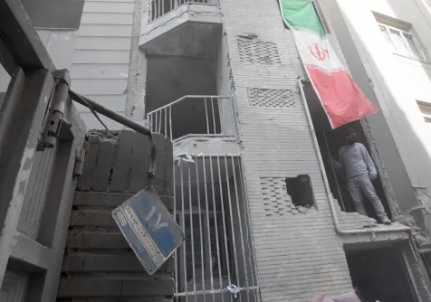 رجل داخل مبنى متضرر بضربة في طهران خلال الحرب الأميركية - الإسرائيلية مع إيران بعدسة المصورة يلدا معيري المحكوم عليها بالسجن 15 عاماً (رويترز)