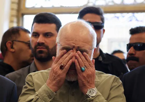 رئيس البرلمان الإيراني محمد باقر قاليباف باكياً في النجف العراقية يوم الجمعة عند قبر أبو مهدي المهندس الذي قُتل إلى جانب قاسم سليماني في غارة أميركية في يناير 2020 (رويترز)