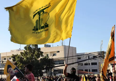 أنصار لـ«حزب الله» يلوحون بأعلام الجماعة في الضاحية الجنوبية لبيروت (أ.ف.ب)