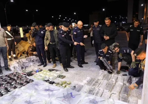 ضباط من الشرطة في الأنبار العراقية يعاينون مقذوفات ومسيَّرات ضُبطت بالمحافظة (إعلام أمني)