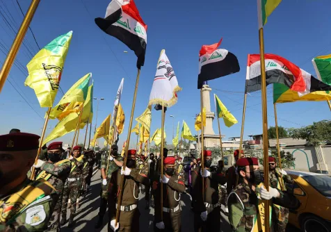 مقاتلون من الفصائل العراقية في جنازة ببغداد لعناصر قُتلوا بضربة أميركية خلال ديسمبر 2023 (أ.ف.ب)
