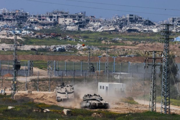 İsrail tankları Gazze sınırında ilerlerken arka planda Gazze Şeridi'ndeki tüm mahalleler görülüyor (AFP)