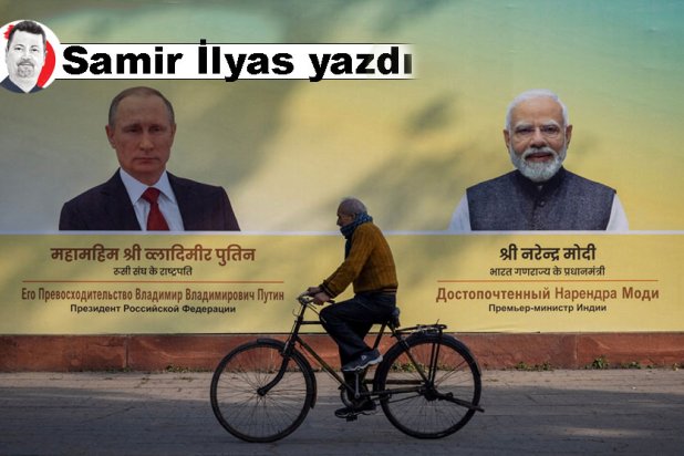 Yeni Delhi'de Hindistan Başbakanı Narendra Modi ve Rusya Devlet Başkanı Vladimir Putin'in fotoğraflarının önünde bisiklet süren bir adam, 4 Aralık 2025 (Reuters)