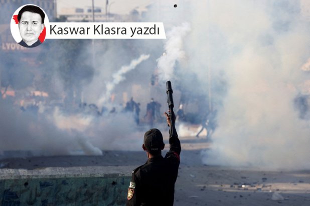 Pakistan'ın Karaçi kentindeki parlamento binası önünde düzenlenen protesto gösterisini dağıtmak için göz yaşartıcı gaz bombası atan bir polis memuru, 1 Mart 2026 (Reuters)