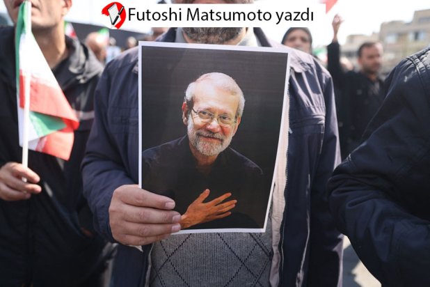 Tahran'da Besic güçleri komutanı ve kıdemli bir İran Devrim Muhafızları subayı olan Gulam Rıza Suleymani ve İran güvenlik şefi Ali Laricani'nin cenaze töreni sırasında Laricani’nin fotoğrafını taşıyan birisi, 18 Mart 2026 (AFP)