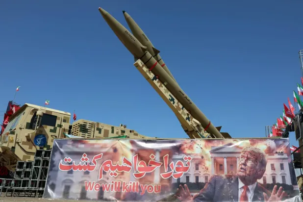 Tahran’daki Azadi Meydanı’nda, İran’a ait bir füze sisteminin yanında, ABD Başkanı Donald Trump’ı öldürmekle tehdit eden bir pankart, 30 Temmuz 2026 (Reuters)