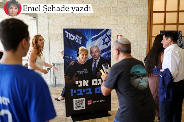 Knesset seçimleri öncesinde Likud Partisi ön seçimlerinde bir İsrailli kadın Netanyahu'nun seçim afişiyle poz veriyor, 17 Ağustos Pazartesi (Reuters)