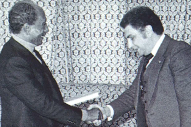 بسيوني مع أنور السادات في ميت أبو الكوم حين استضافه وأهداه  أحد كتبه