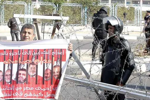 مصري يطالب بإعدام قادة الإخوان أمام أكاديمية الشرطة بالقاهرة مقر جلسات محاكمة مرسي