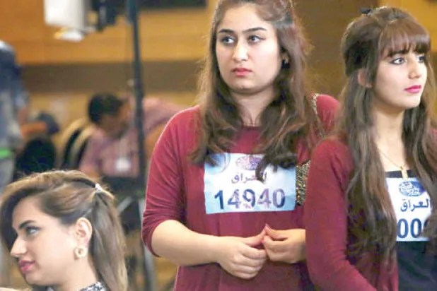 شابتان عراقيتان تنتظران دورهما للوقوف أمام لجنة اختبار برنامج (عرب آيدول) في أربيل (أ.ف.ب)