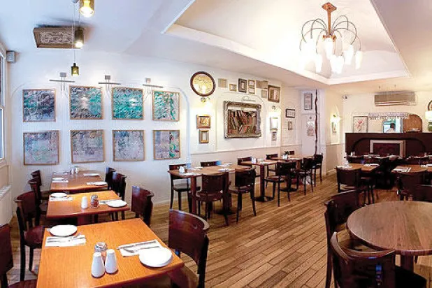 مطعم حافظ من الداخل وتبدو فيه لوحات لخطاطين ايرانيين على الحائط