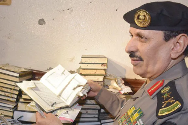 مدير الأمن العام يمسك بمصحف تسبب التفجير الانتحاري في تمزقه (واس)