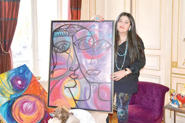 الفنانة شاليمار شربتلي مع إحدى لوحاتها في بيتها في باريس