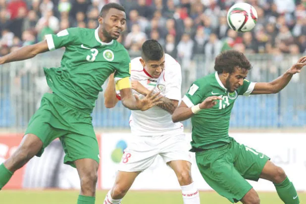 مدافعا الأخضر الشهراني وهوساوي يتصديان لإحدى الهجمات الفلسطينية (أ.ف.ب)