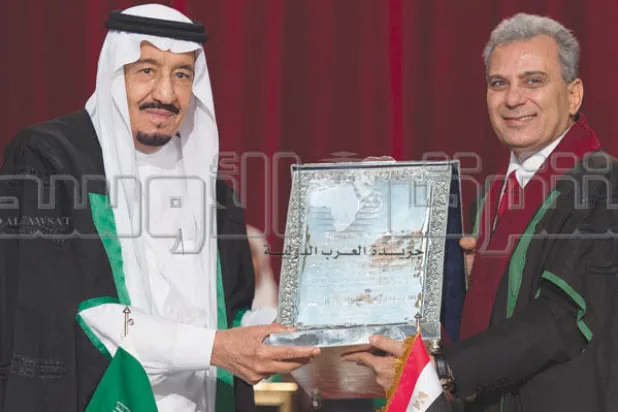 خادم الحرمين الشريفين يتسلم من مدير الجامعة درجة الدكتوراه التي حفرت في إطار من الفضة (تصوير: بندر الجلعود)
