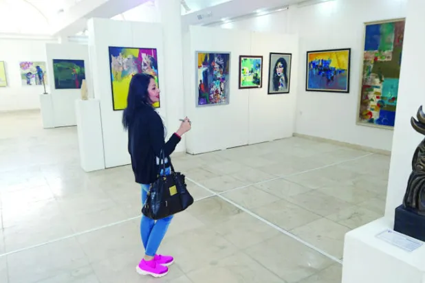 الفنانة التشكيلية مينا الحلو تتأمل أعمال المعرض ({الشرق الأوسط})