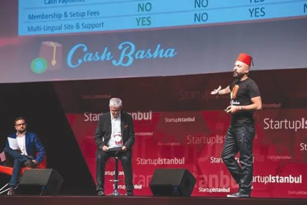 فؤاد جريس على خشبة المسرح في إسطنبول مرتديًا طربوشًا أحمر يقدم موجزًا عن شركته الناشئة «كاش باشا» («الشرق الأوسط»)