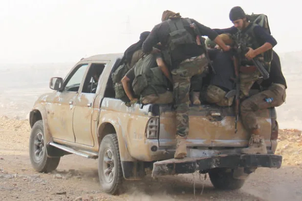 عناصر من جبهة فتح الشام (النصرة سابقا) بعد إحدى معاركهم قرب مدينة حلب ({غيتي})