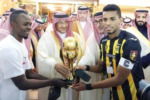 نائب خادم الحرمين الأمير محمد بن نايف لدى تتويجه قائد الاتحاد بكأس ولي العهد بحضور ولي ولي العهد الأمير محمد بن سلمان (هيئة الرياضة)