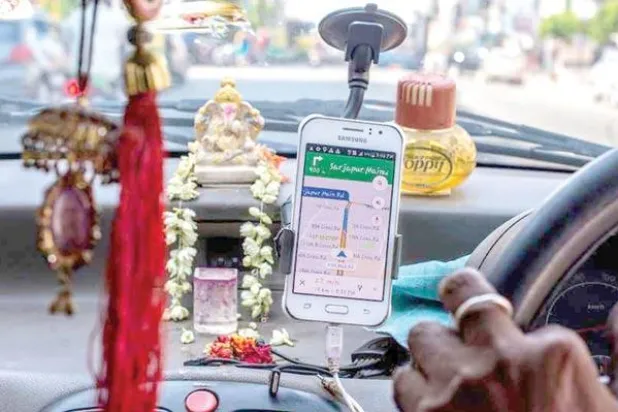 سائق «أوبر» يستخدم تطبيق الهاتف الذكي للتجول في شوارع بنغالور شديدة الازدحام ({نيويورك تايمز})